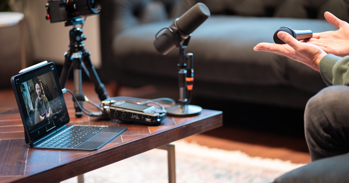 Podcast recording setup with camera, microphone, and laptop in a modern studio, representing ElevenLabs AI voice production for podcasts