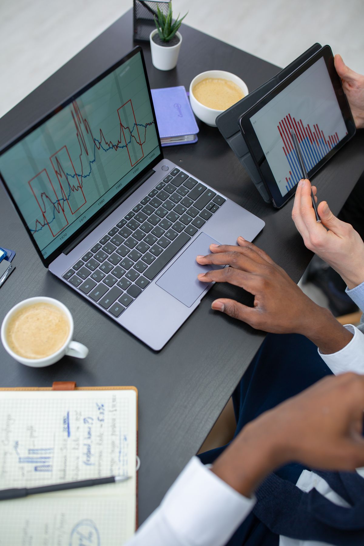 A person organizing presentation sections on a laptop with notes