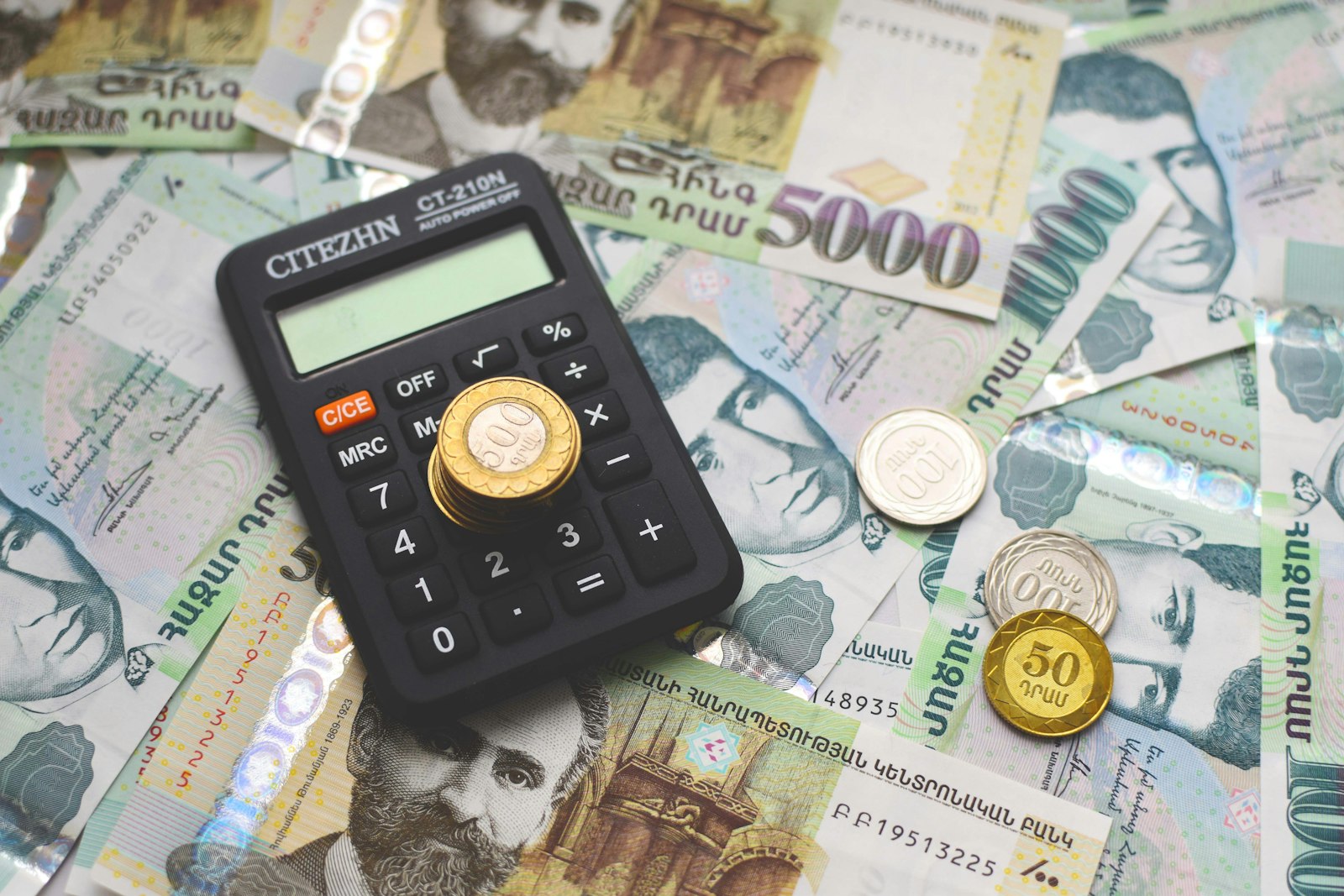 Calculator on top of money, representing calculating software subscription costs