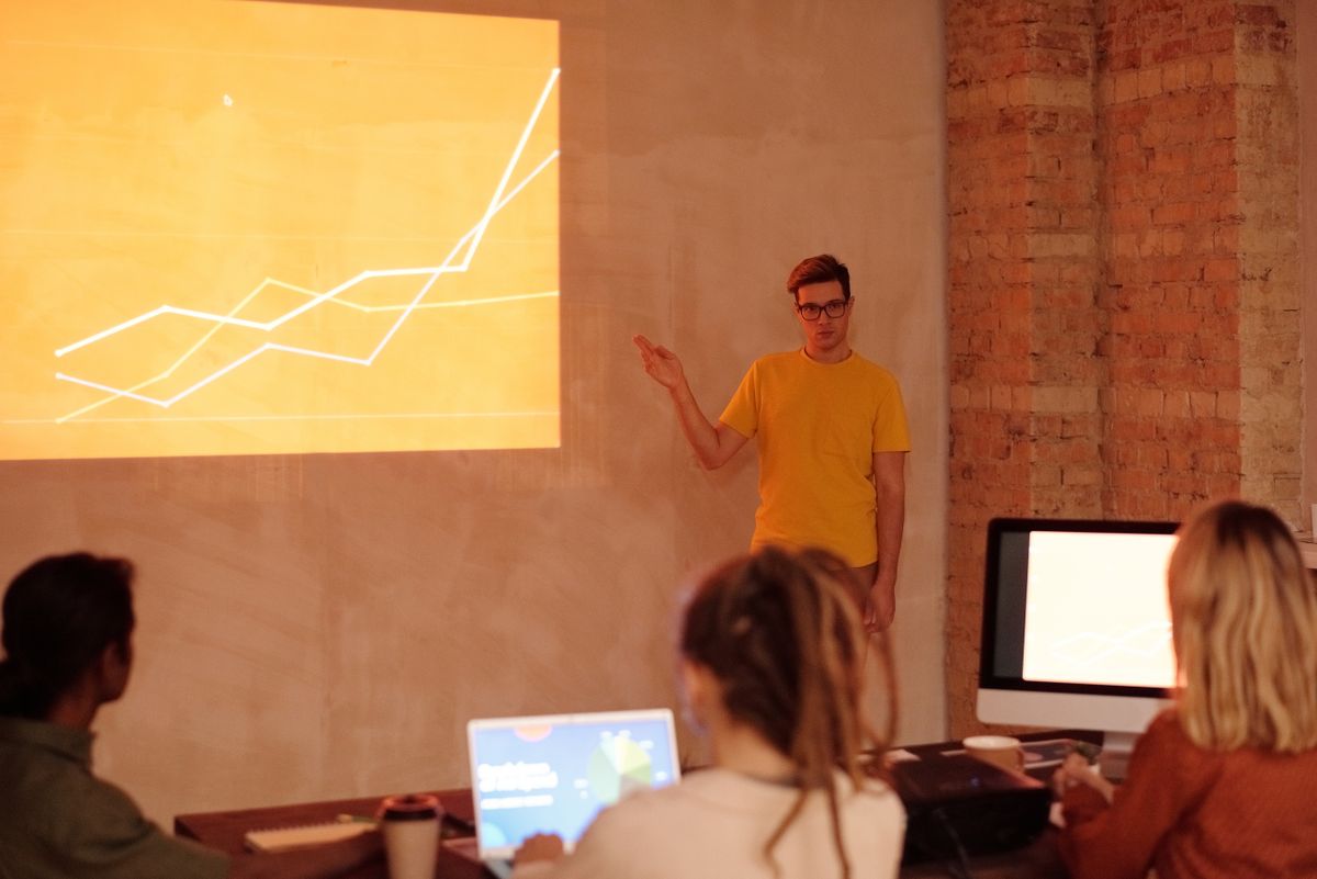 A professional presents data-analysis charts during a modern office meeting