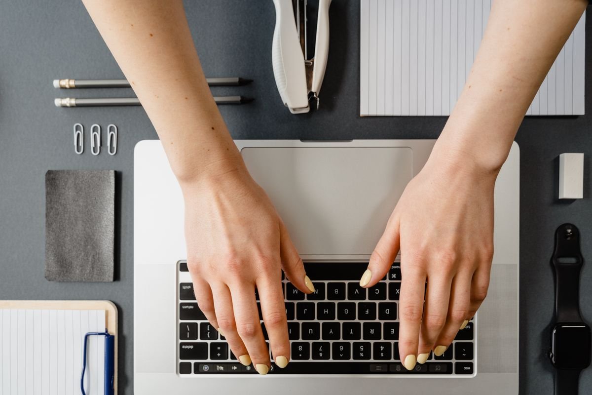 A person working on a document at a laptop before converting it into slides