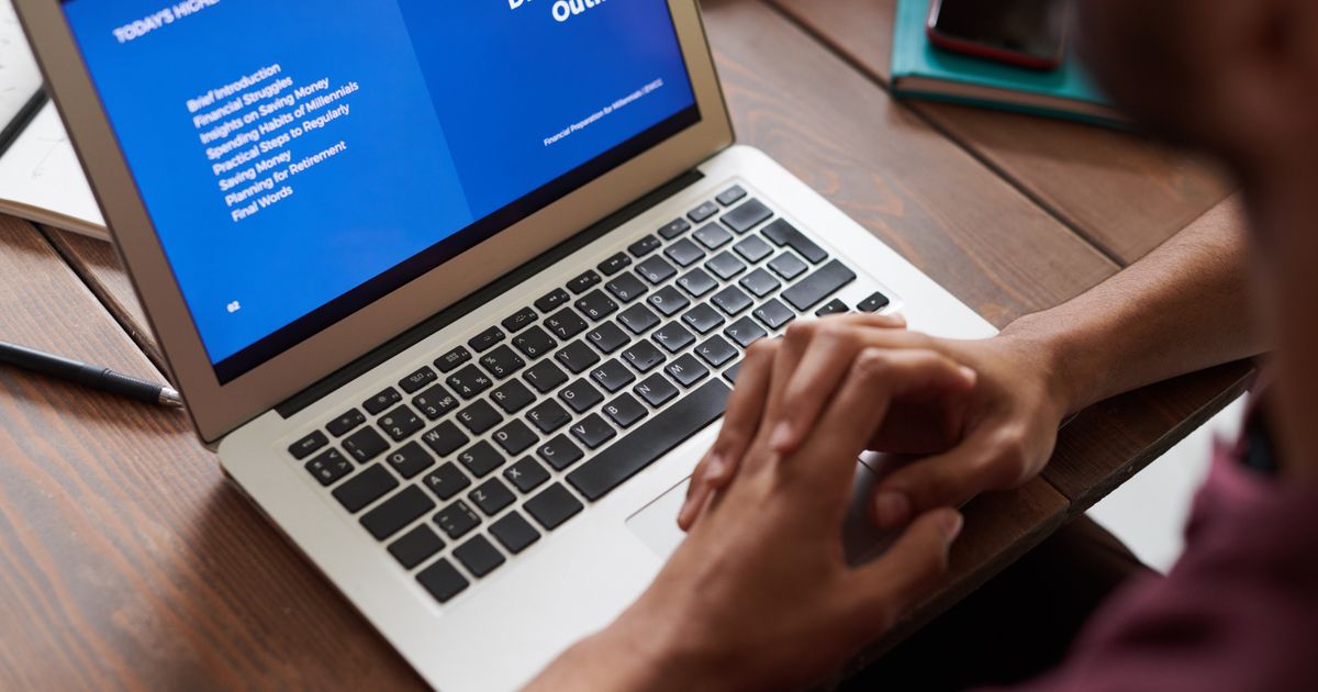 A professional reviewing a presentation on a laptop while evaluating AI presentation tools