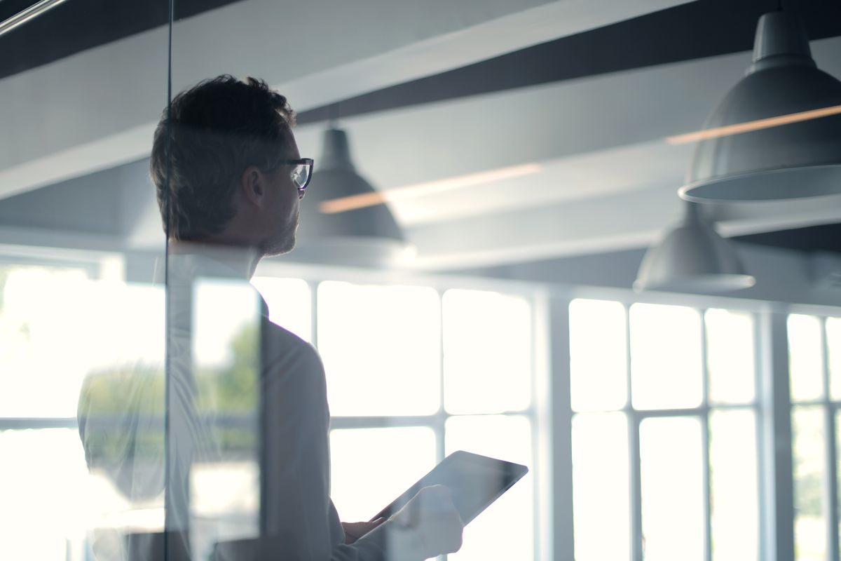 A person giving a presentation from a tablet in a modern office, without a PowerPoint deck