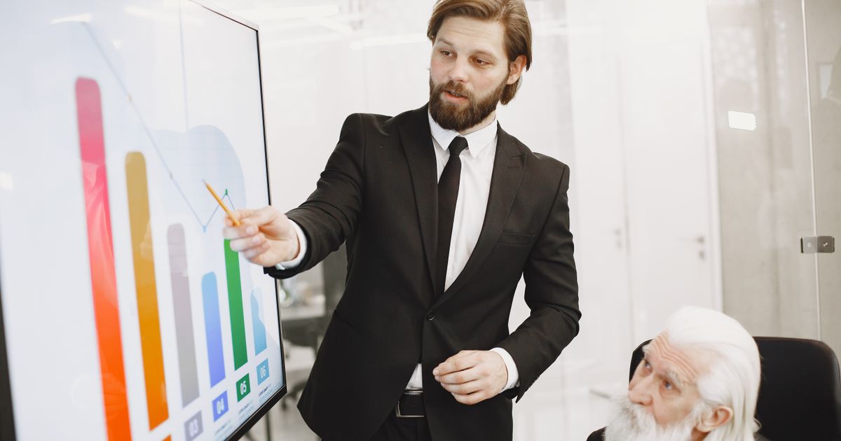Two colleagues discussing presentation data trends on a screen