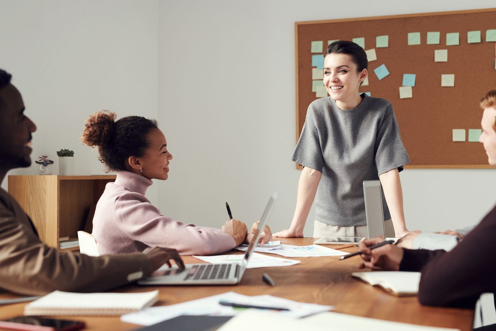 A woman leading a presentation to colleagues around a table