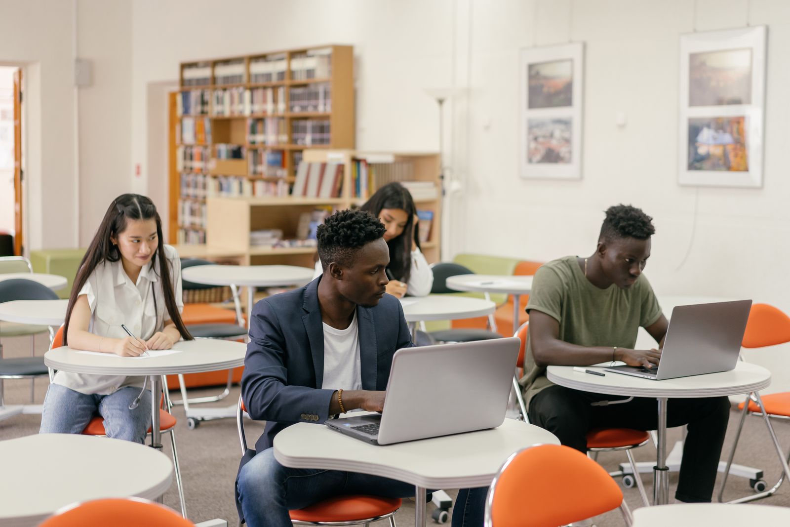 A student working thoughtfully on a laptop while preparing coursework