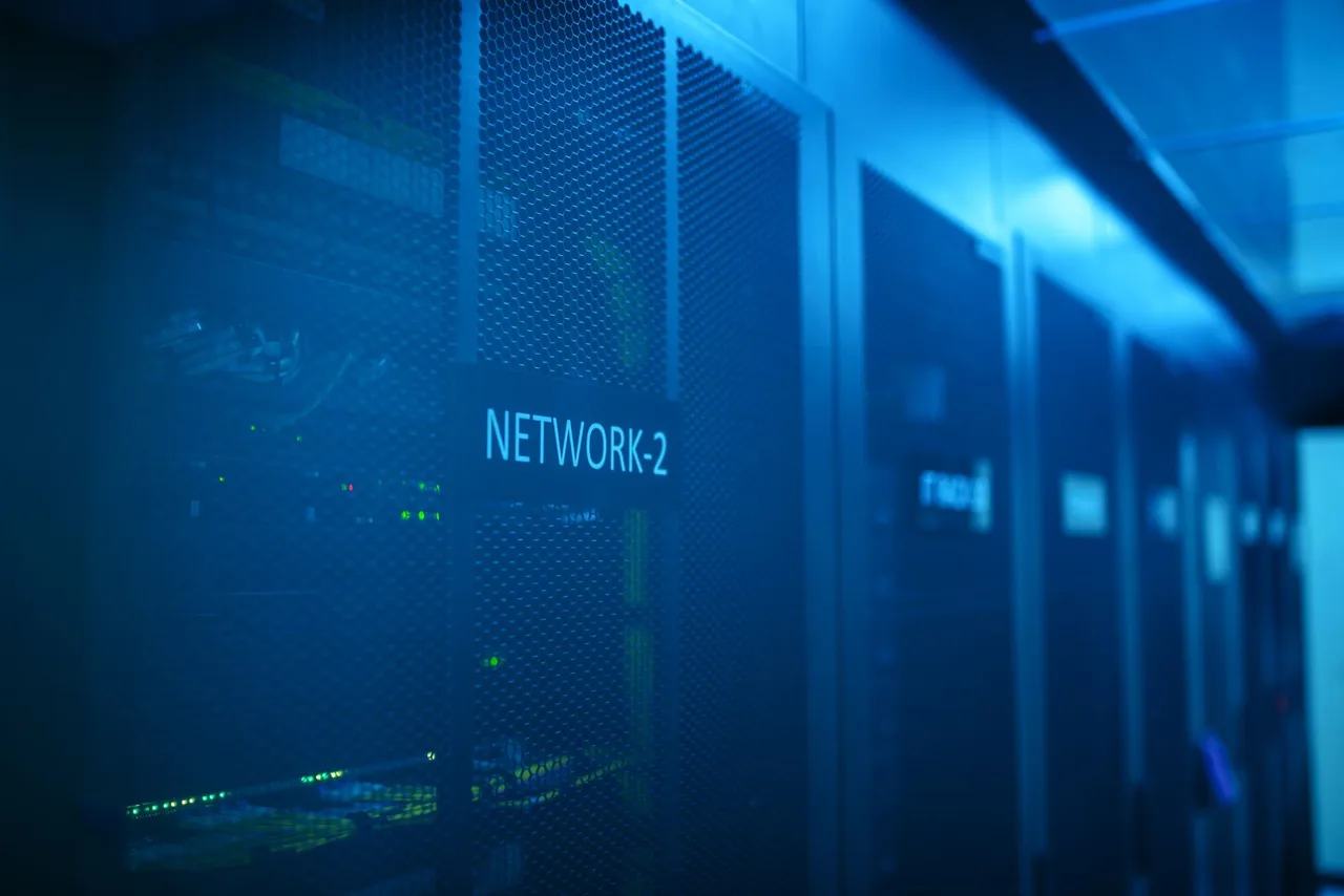 Blue-lit network switch and server racks in a data center aisle