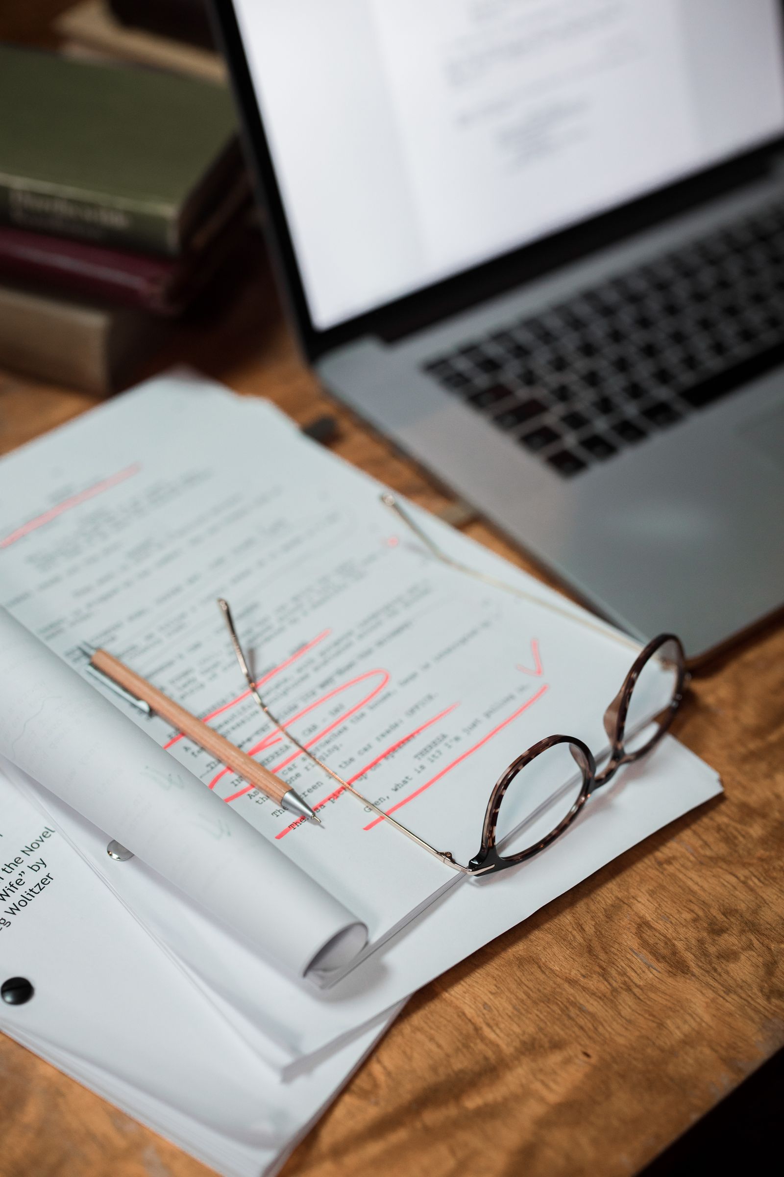 A person reviewing source material and notes on a laptop