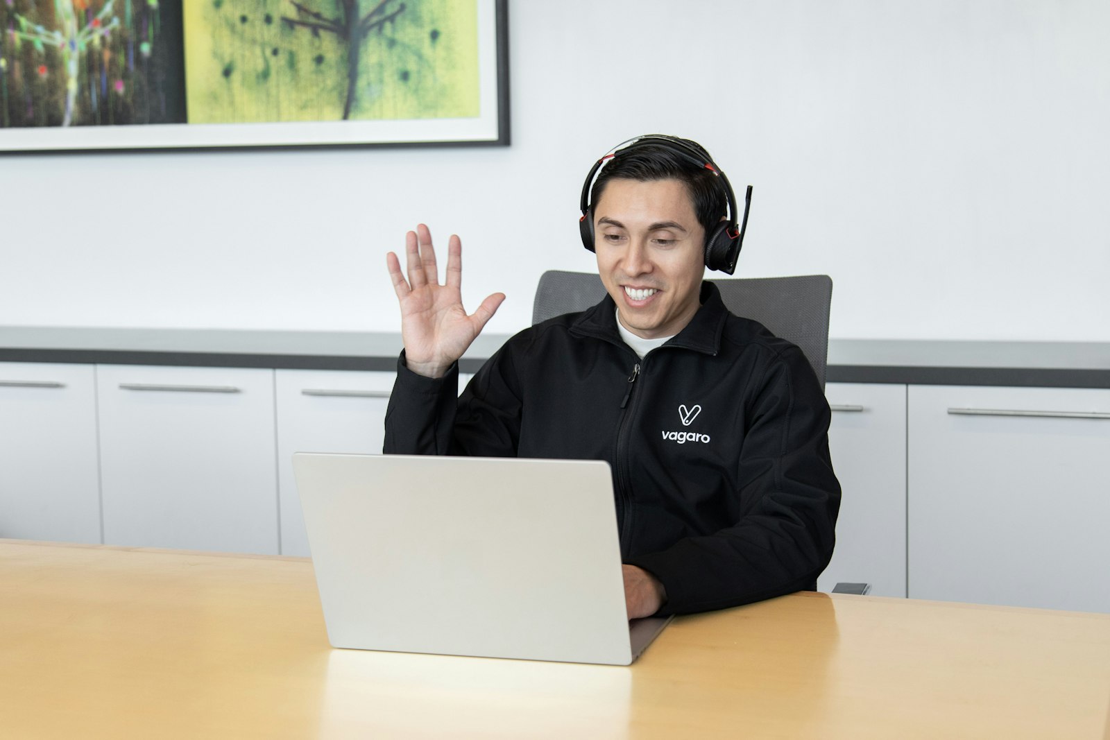 Man wearing headphones using an AI voice agent platform on his laptop