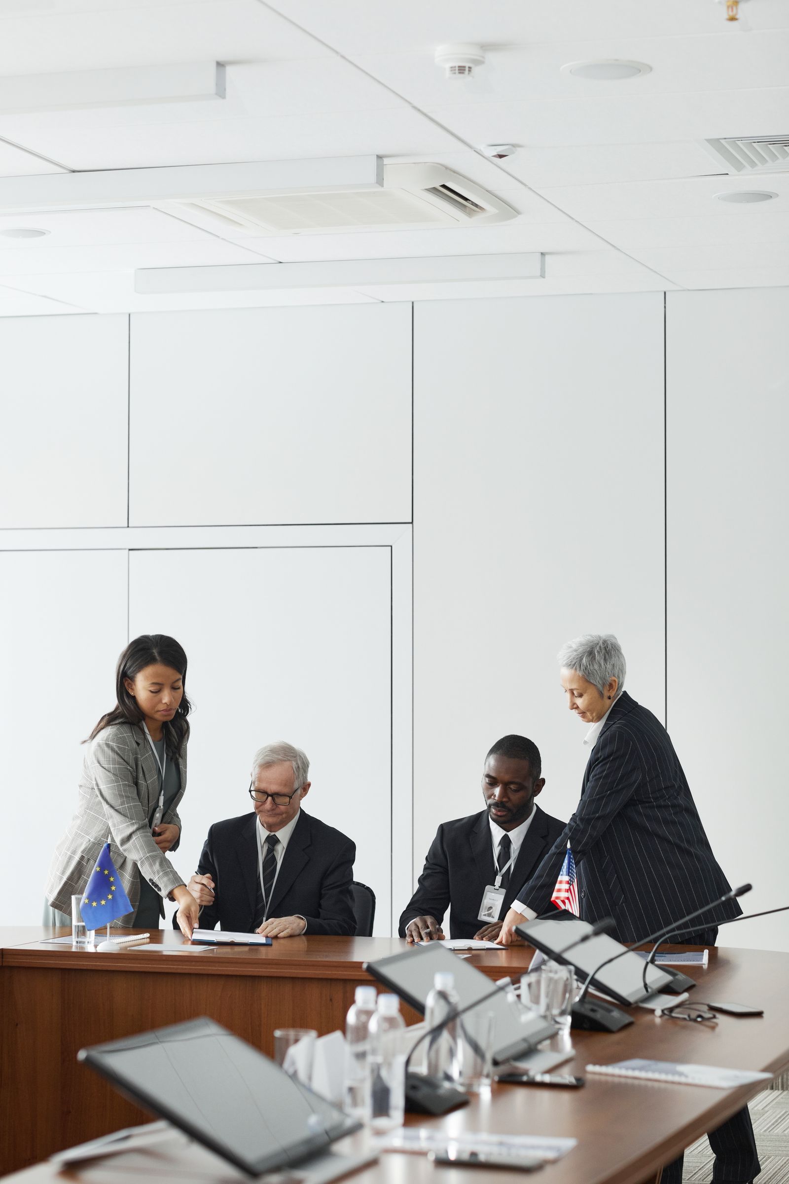 An international team collaborating around a laptop in a meeting room