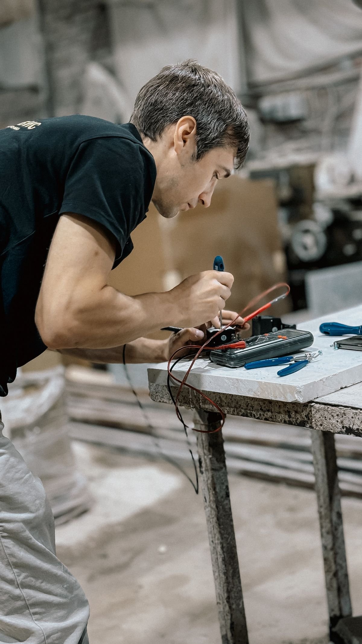 An electrical engineer testing equipment with a multimeter on site