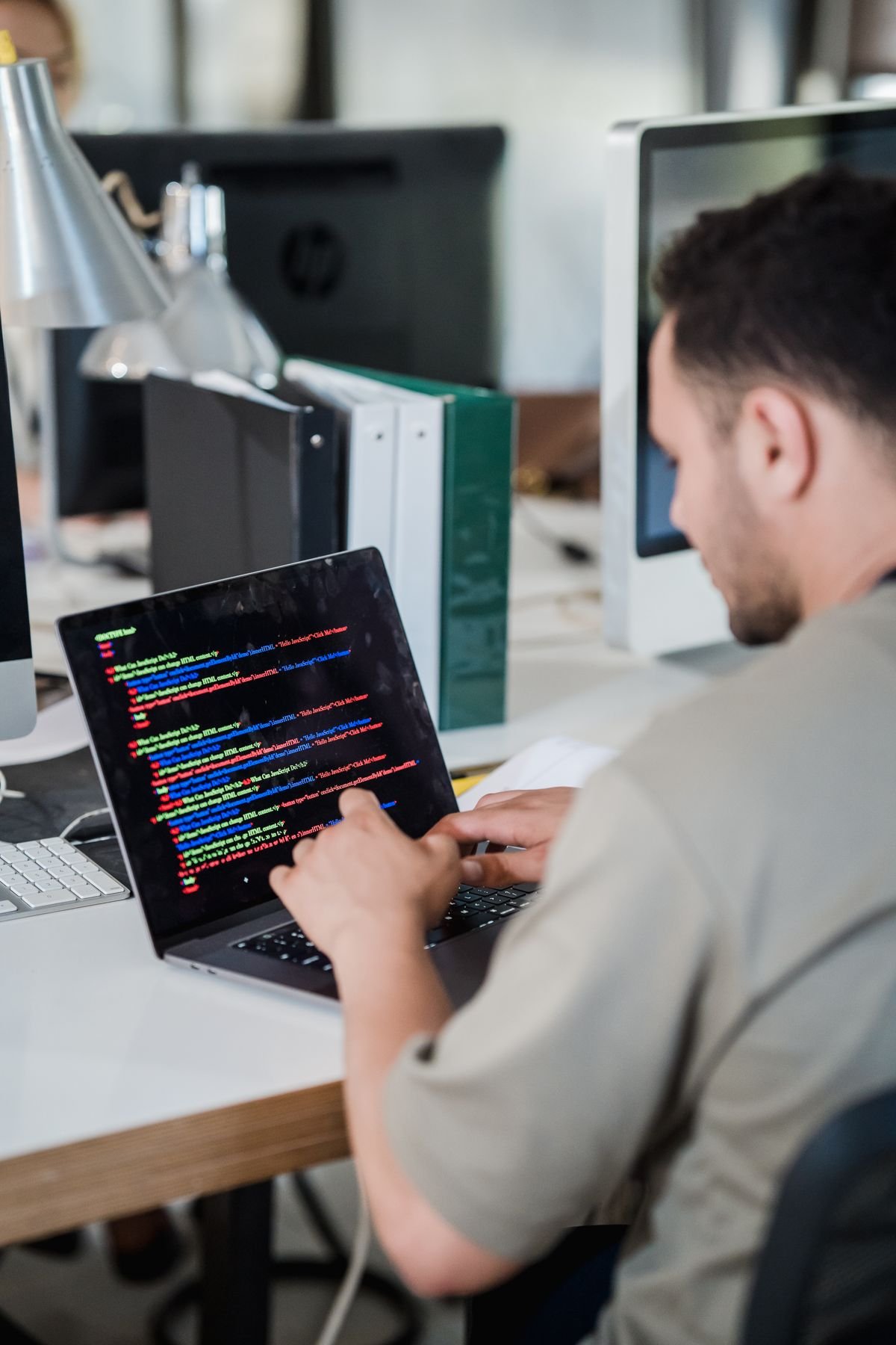 An engineer writing documentation on a laptop in a modern office