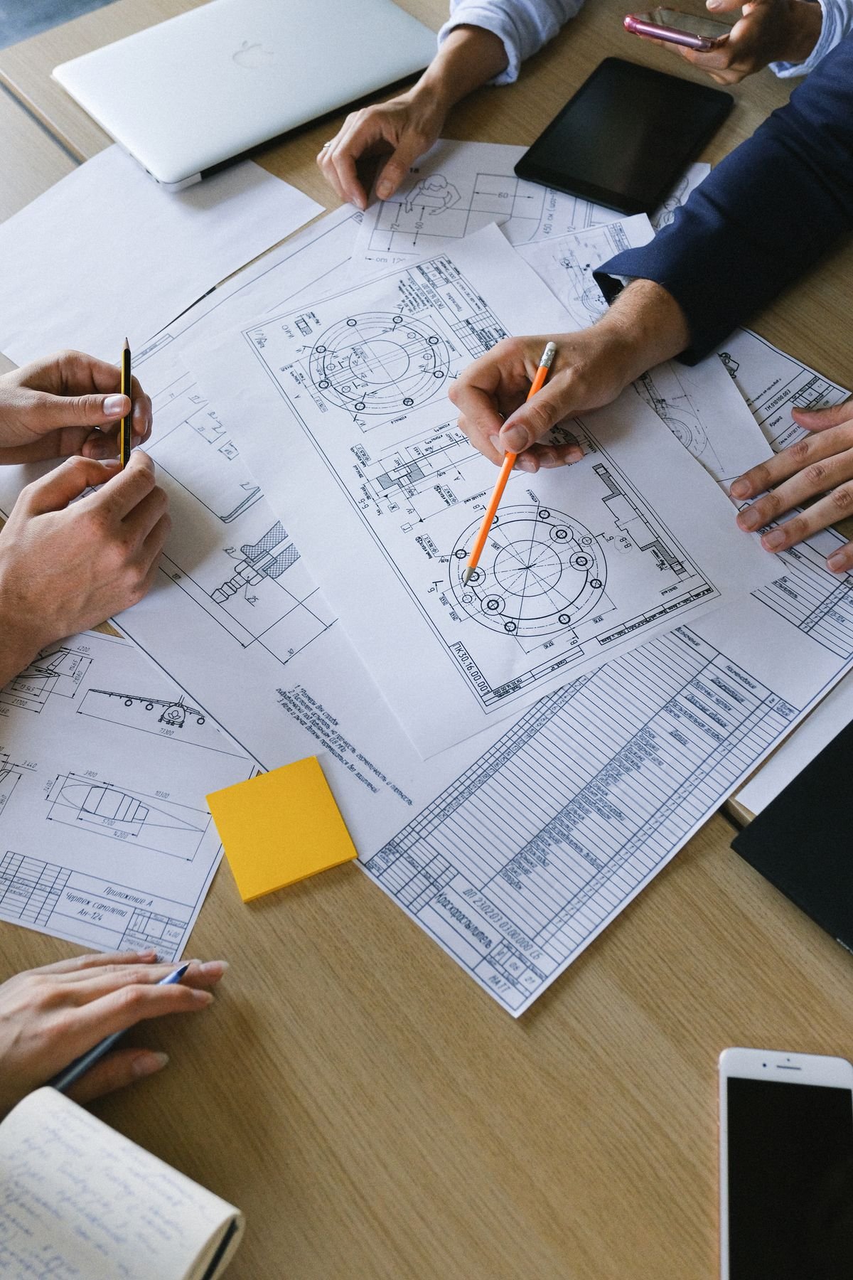 A small engineering team reviewing project drawings together around an office table