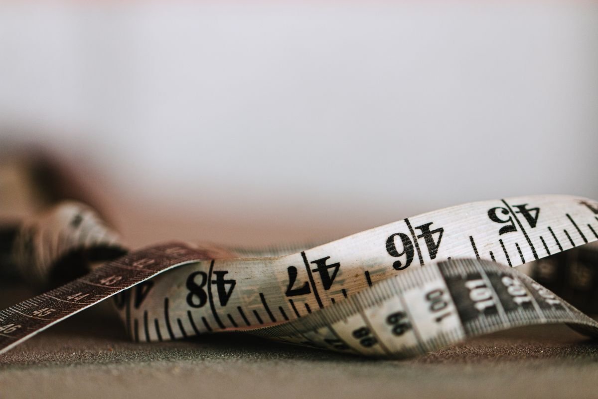 A tailor's tape measure showing both inch and centimeter markings, representing unit conversion between systems
