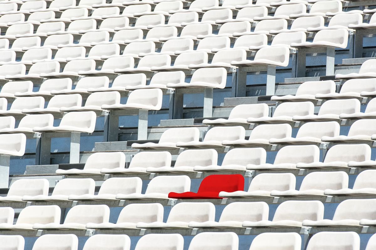 A single red seat standing out among rows of white stadium seats, representing one clear pick