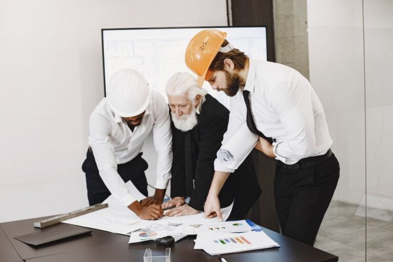 A diverse group of engineers reviewing project blueprints together in an office
