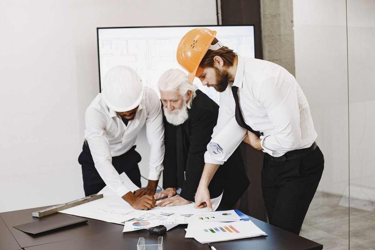 A diverse group of engineers reviewing project blueprints together in an office