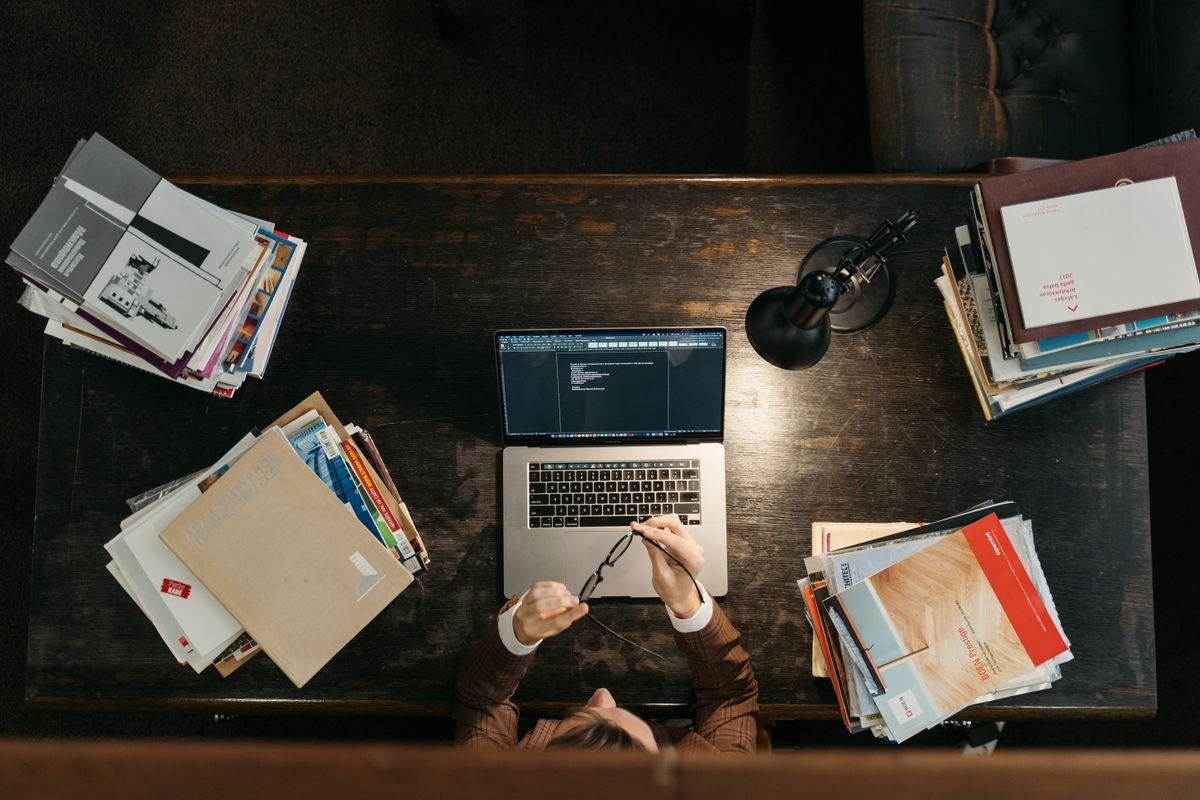 Engineering student working on a laptop at a desk covered with notes and study materials