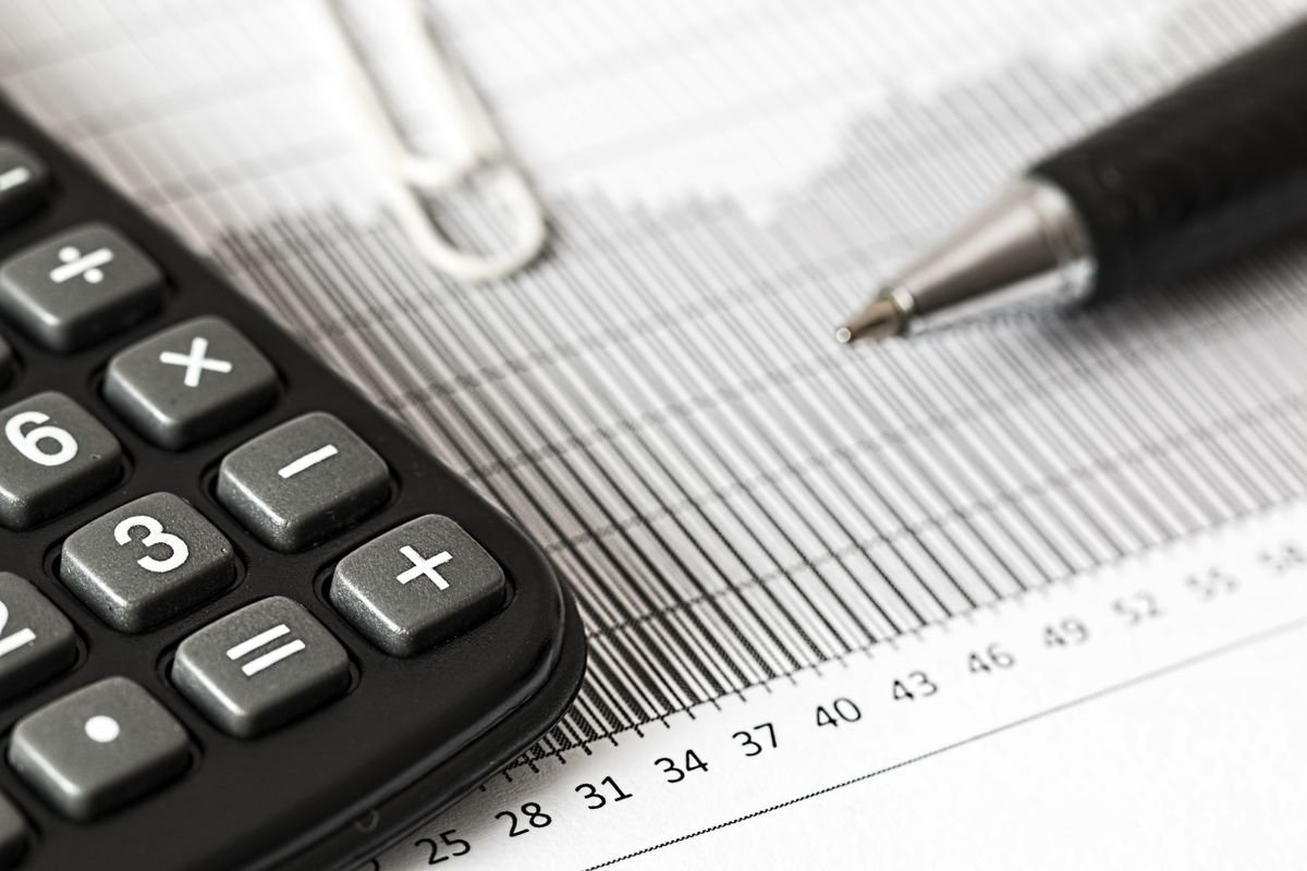 Calculator and pen resting on a printed data chart