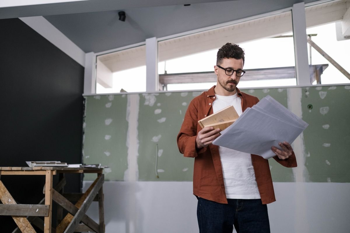 Focused architect examining construction plans indoors