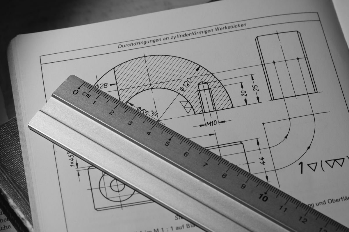 Black and white technical drawing with a metal ruler on top