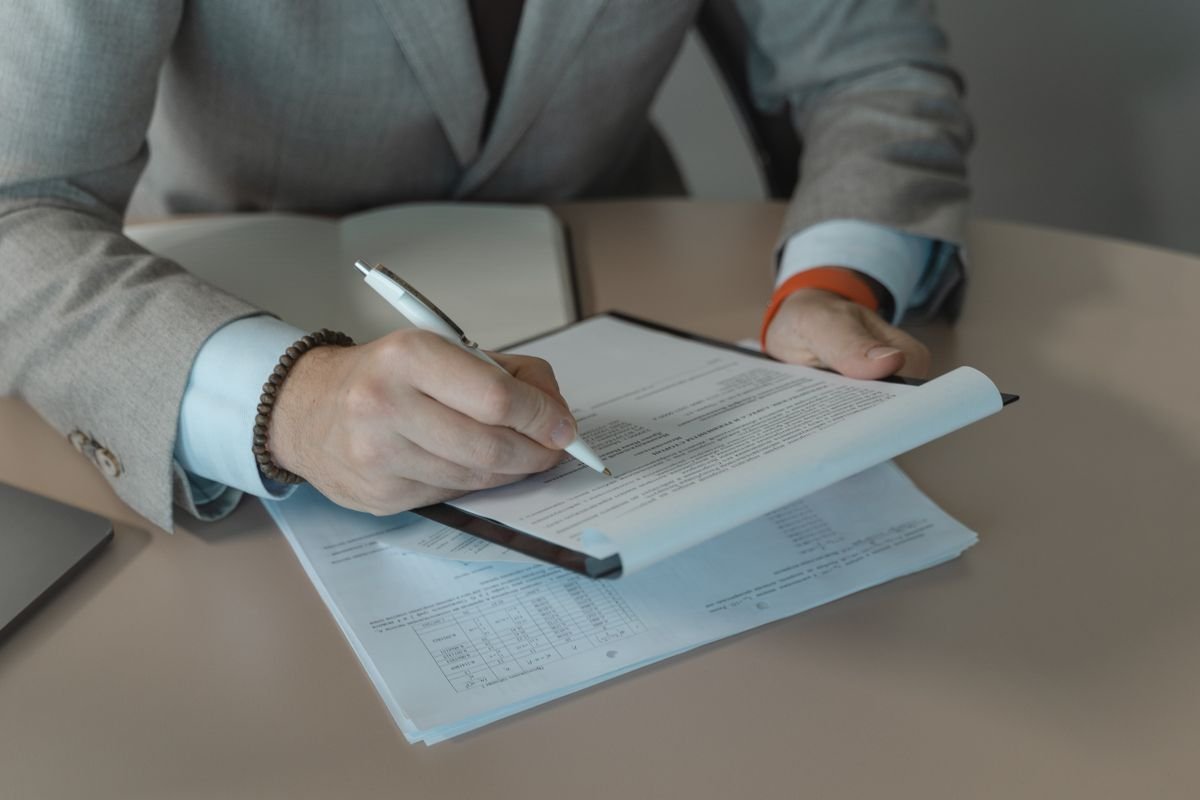 Professional reviewing and signing a document with a pen