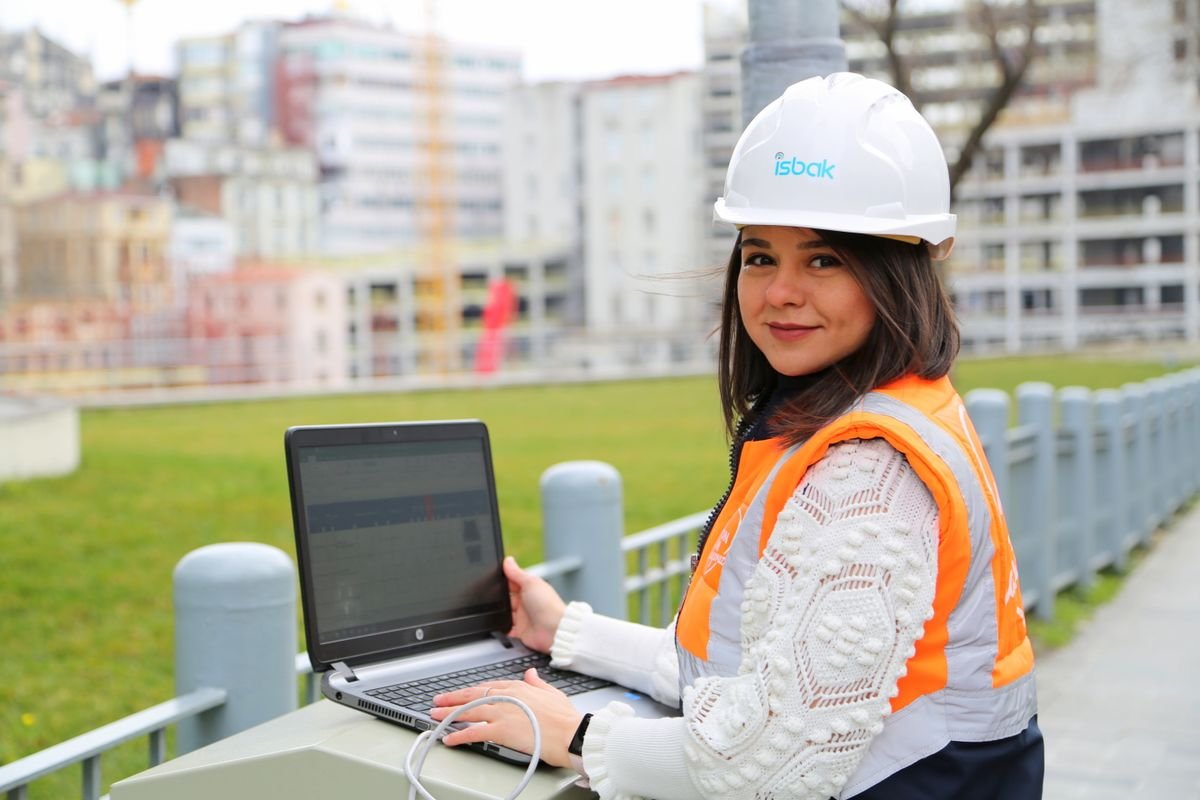 Civil engineer typing on a laptop at an outdoor construction site