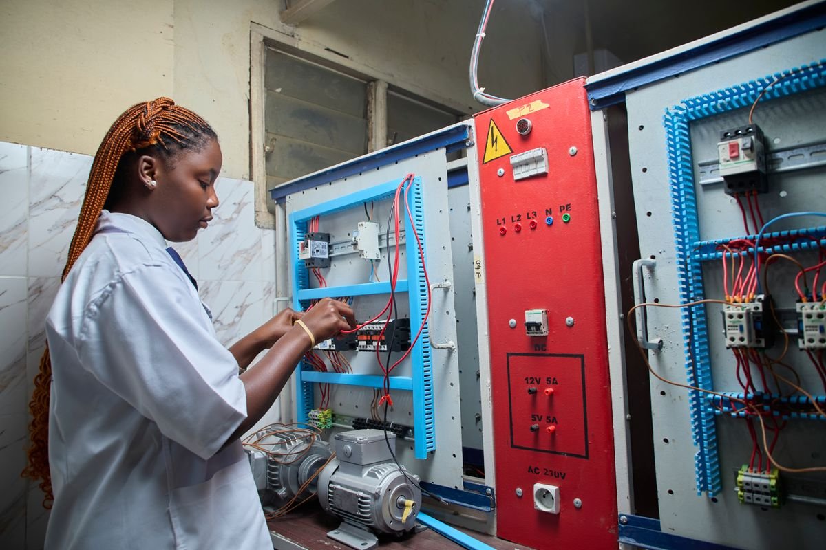 Technician working on an electrical control panel with wiring