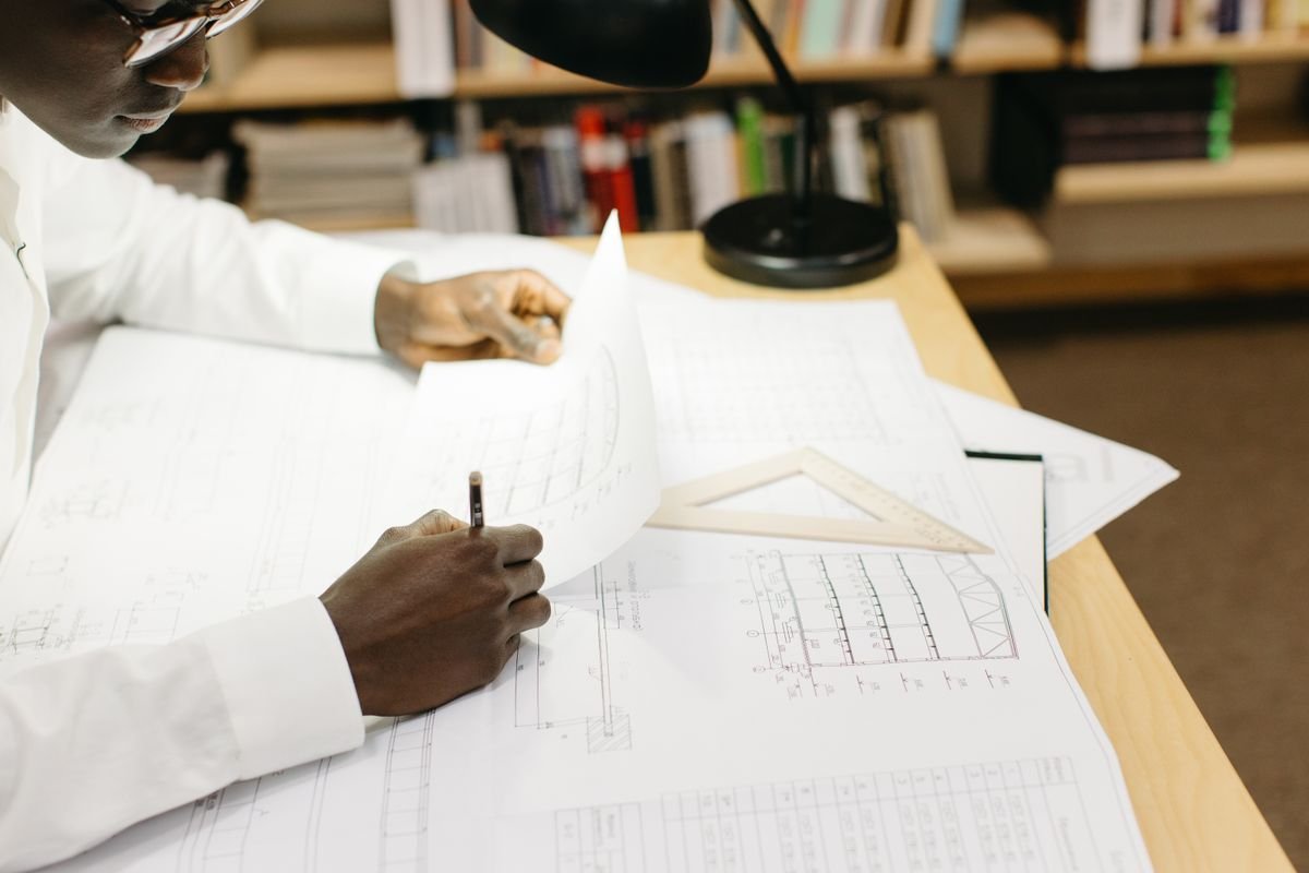 Engineer at a desk studying project blueprints in an office