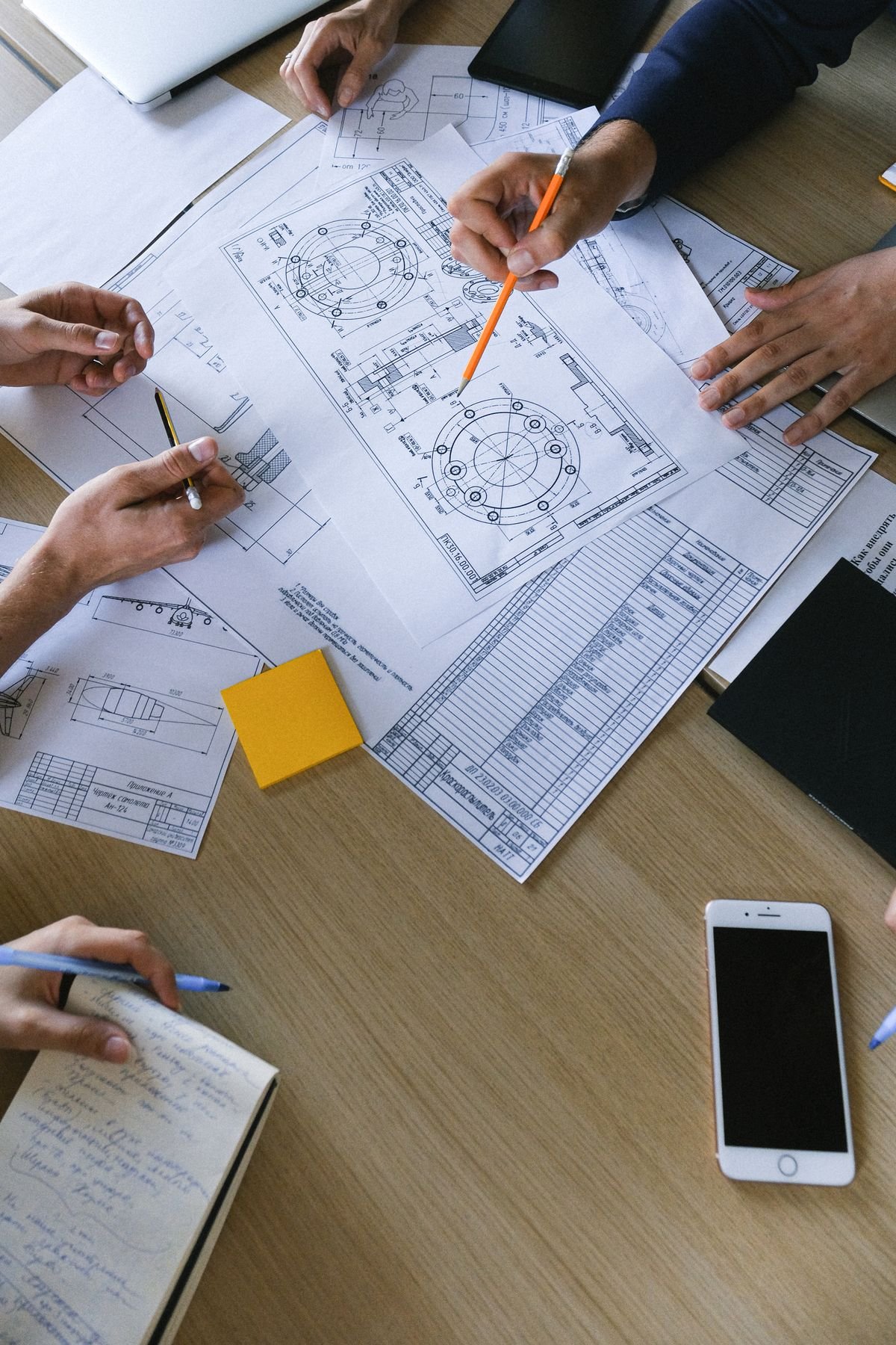 Engineers reviewing plans and documents together on a table