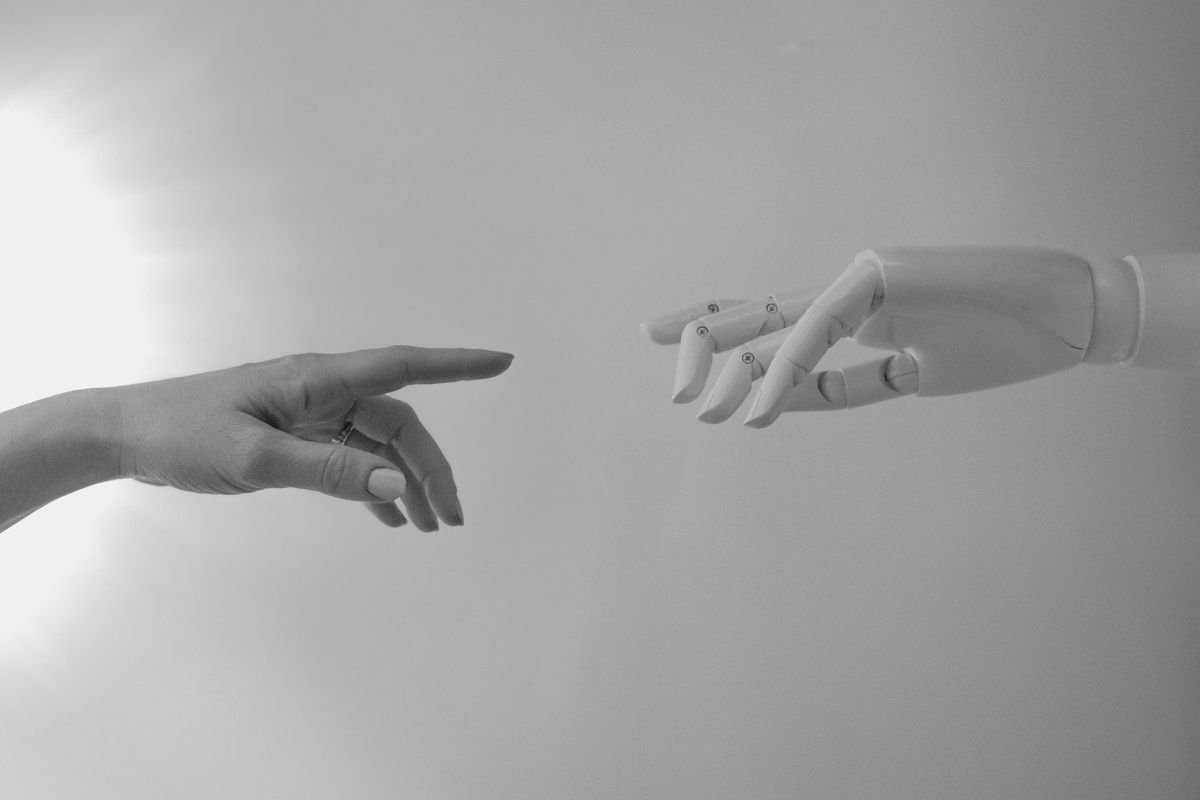 A human hand and a robotic hand reaching toward each other