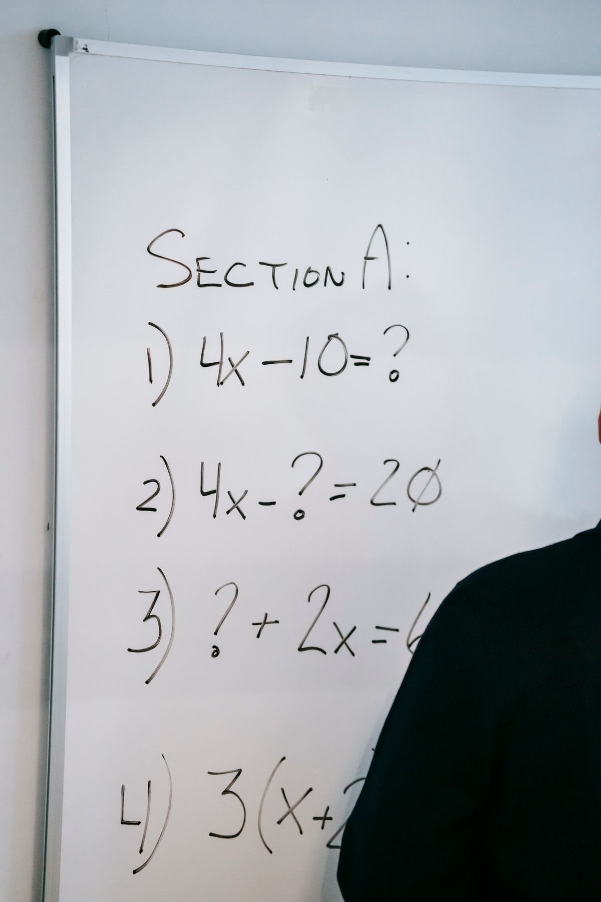 A whiteboard listing a set of algebra test questions labelled Section A