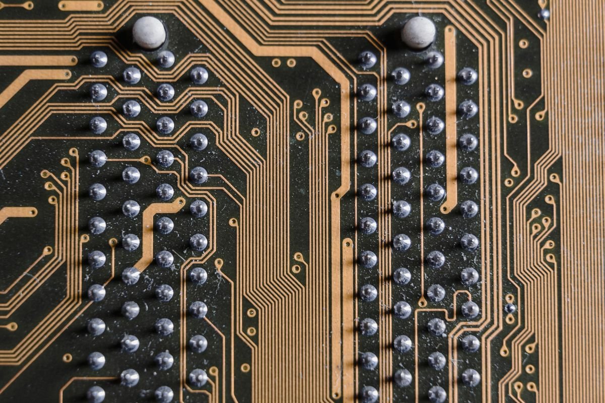 Close-up of a printed circuit board showing copper traces and rows of solder pads