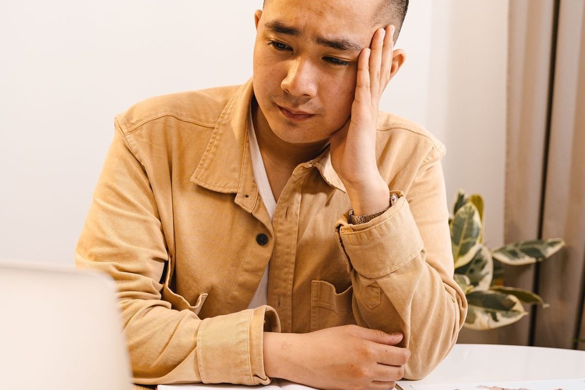 A frustrated engineer sitting at a laptop, illustrating problems with AI CAD software