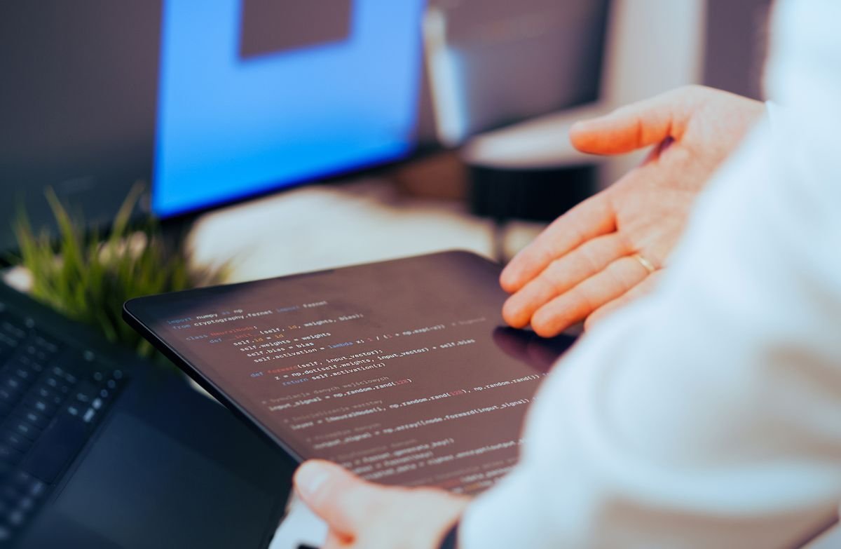 Engineer reviewing code on a tablet in an office